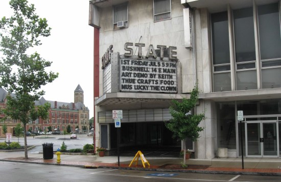Theater marquee advertising local events and performers coming in July 2013 -- an art demo, food crafts, a clown, etc.