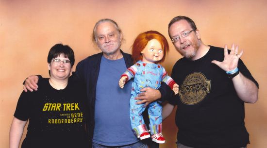 us waving next to Brad Dourif, who's holding a Chucky doll.