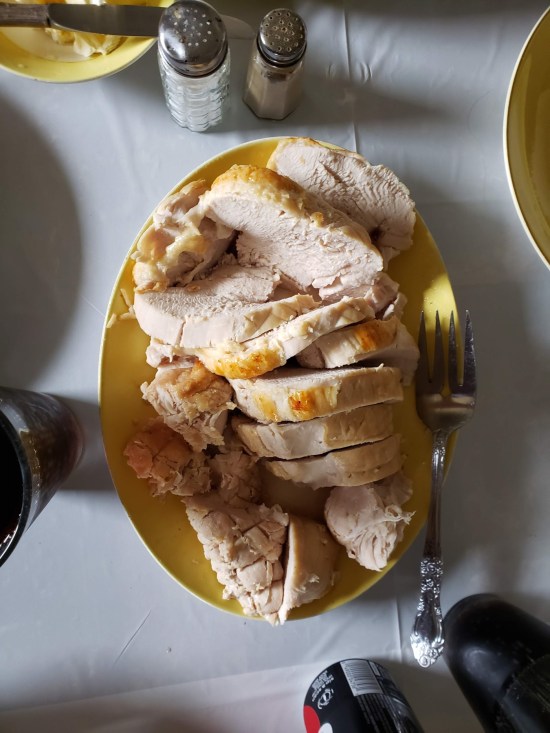 Large serving plate of thick-sliced roasted turkey.