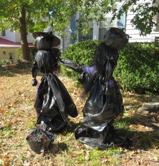 witches on front lawn with trash bags for dresses