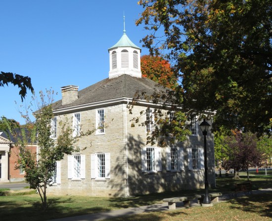 A closer shot of the Old State Capitol building in Corydon with more shadows from the nearby trees.