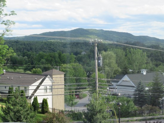 Waterbury hotel window view mountains outnumbering  houses.