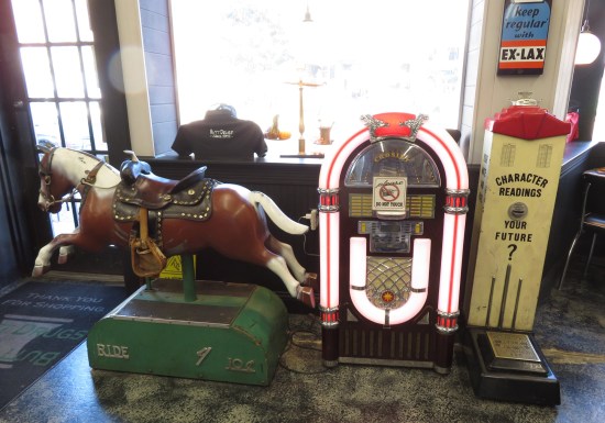 A coin-operated riding horse, jukebox, and scales.