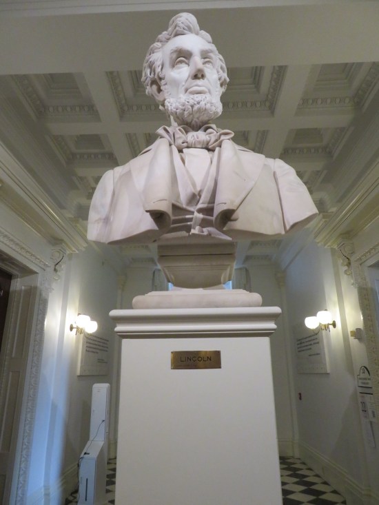 An Abraham Lincoln bust in the middle of a hallway, shot from below to make him more imposing.