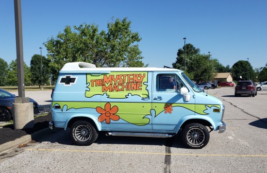 A Mystery Machine van (from "Scooby-Doo") in a church parking lot for no apparent reason.