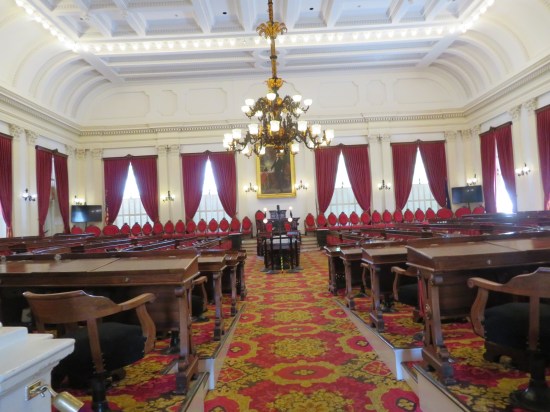 A roped-off view of a state congressional chamber, red carpet.