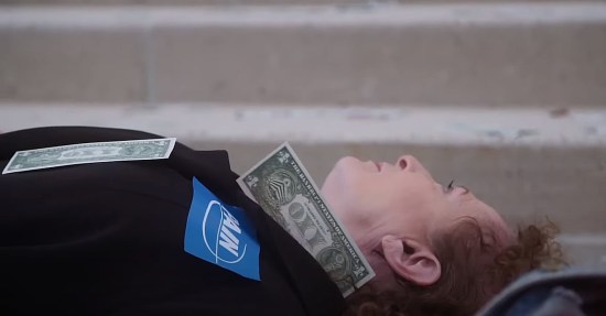 Nan Goldin lying down in front of a museum as a protest against the Sacklers. Fake dollar bills are stuck to her which read "OXY" instead of "ONE".