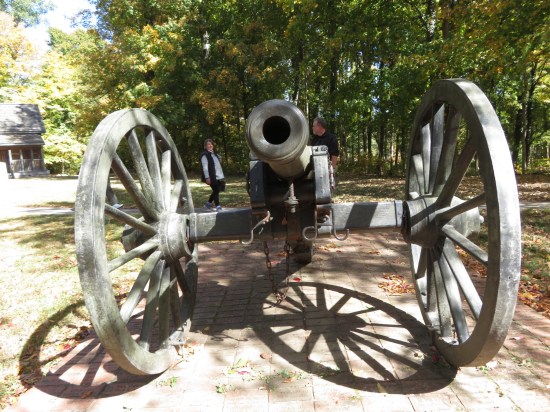 A big cannon pointed at the camera. The heads of myself and our docent are visible in the distance behind it.