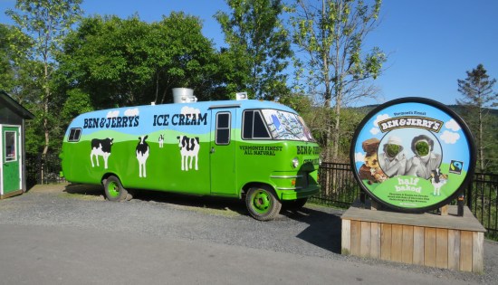 A RV painted green with the company logo and three cartoon cows.