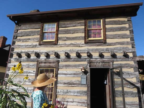A two-story log cabin that used to be various businesses but is now an old-timey museum.