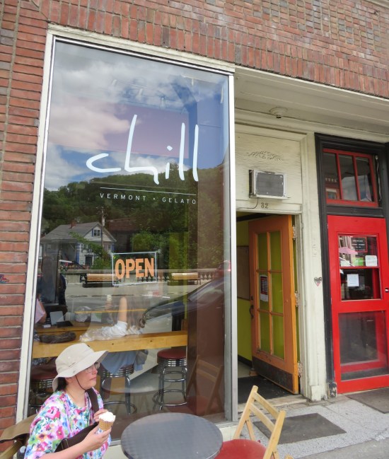 Anne sits with a waffle cone in front of a snack shop.