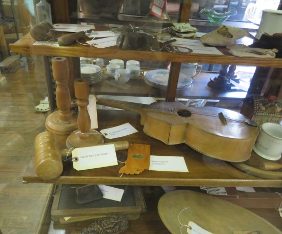 A display case of items made from the wood of the same extremely old tree.