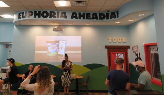 A waiting room with a faint slideshow. Written at the top of the wall is "Euphoria Aheadia!"