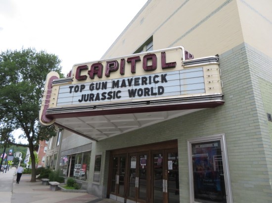 A theater marquee with "Jurassic World: Dominion" and "Top Gun: Maverick" now showing.