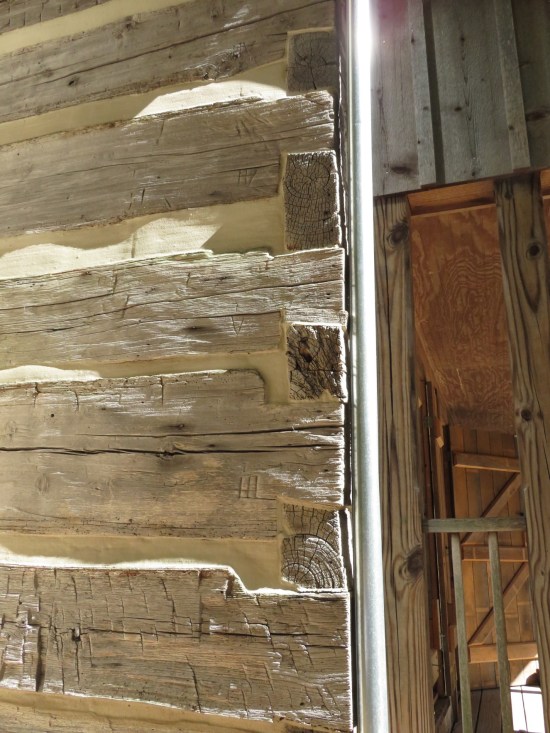 Logs in the cabin wall with Roman numerals etched into the ends in random sequence.