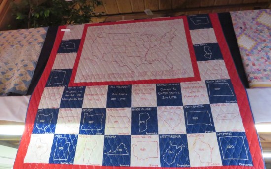 A red, white and blue quilt with patches for every U.S. state.