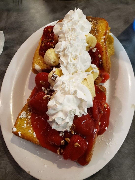 Four slices of French toast topped with everything mentioned in the caption. It is HUGE.