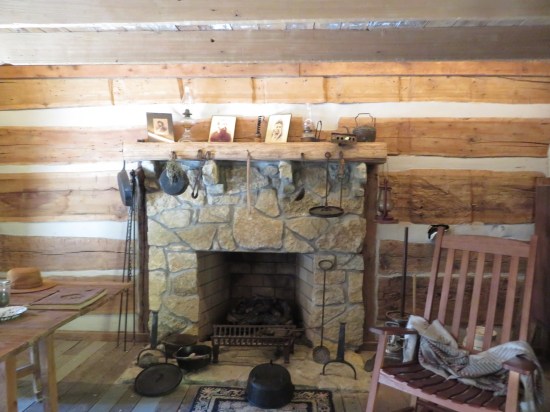 A fireplace in the cabin, lots of tools lying around it.