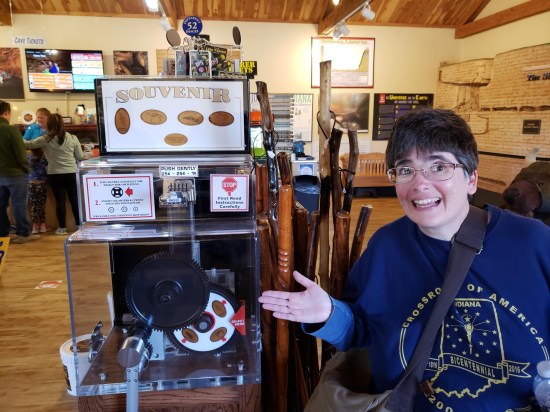 Anne smiling and gesturing to a smashed penny machine.