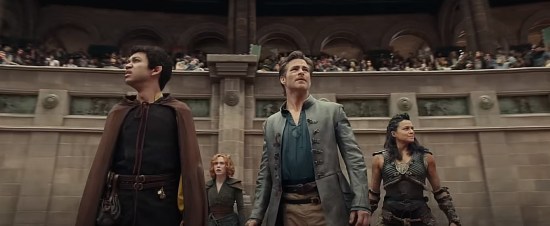 The four main cast members in an arena, gazing upon the surrounding audience and awaiting potential doom.