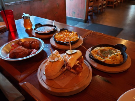 Several dishes on a wood table in a hardwood restaurant. Meal details are described later in the entry.