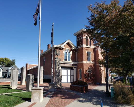 An old firehouse with stone monuments out front.