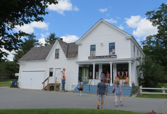 A white general store with tourist heading toward it.