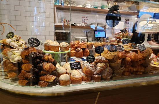 Piles and piles of baked goods on a restaurant counter behind glass.