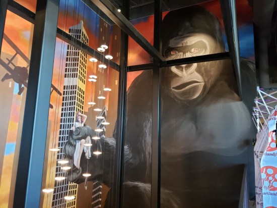 A large painting of King Kong along the entire wall of a long staircase.