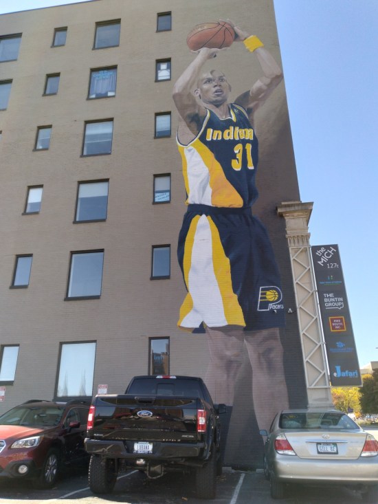 mural: Reggie Miller from the Indiana Pacers with basketball and preparing for a jump shot.