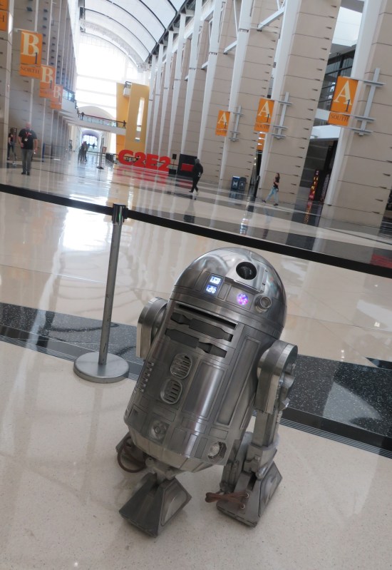 A silver R2-D2 droid shot at an acute Dutch angle. In the distance is the large C2E2 logo that you can pose in front of. It's been around for years.