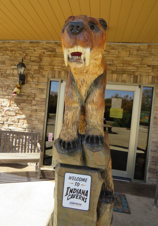 A wood-carved saber-toothed tiger situated on the front porch of the Indiana Caverns gift shop.