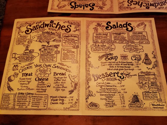 A two-page yellow paper menu, all done up in cutesy handwriting and some sense of whimsical design.