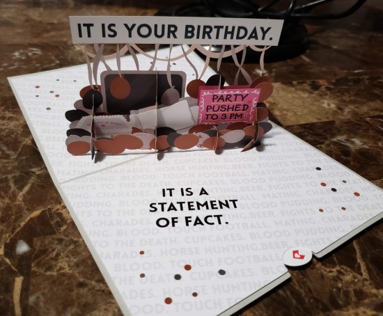 The Office birthday card opened. Message inside: "It is a statement of fact." Also inside is a pop-up desktop holding ugly-colored balloons and an "It is your birthday" Print Shop banner.