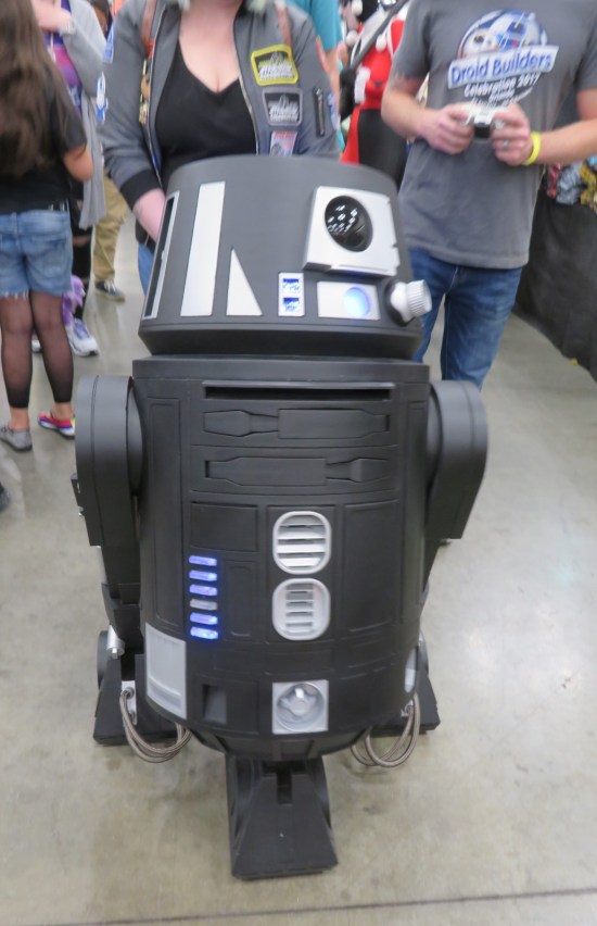 A black-and-silver astromech droid shaped like R5-D4.