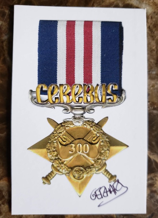 A paper medal autographed by Gerhard with the Cerebus logo, red-white-and-blue trimmings, and crossed swords behind a number 300.