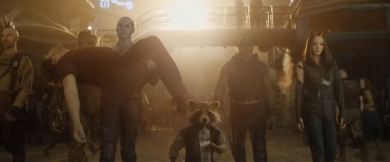 The Guardians dramatically walking toward us. Nebula has to carry the unconscious Star-Lord's dead weight. Everything's sepia-toned.