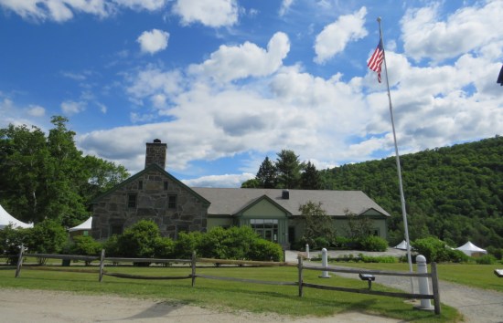 A tidy visitor center in the Green Mountains with a US flag atop a tall pole.