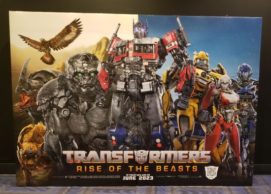 A cardboard standee at the theater with the good-guy Transformers lined up, animals on one side and cars on the other.