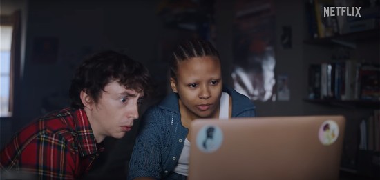 A pale young filmmaker and his cooler girlfriend boggle at an open laptop.
