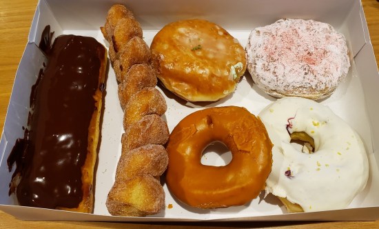 Six donuts in a white box. See caption.