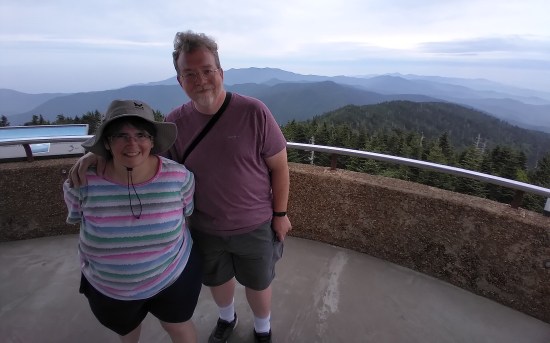 me and Anne standing inside a concrete tower overlooking misty mountains.