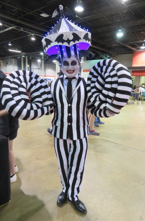 Beetlejuice reenacting the scene where he has roll-up arms and a merry-go-round on his head.