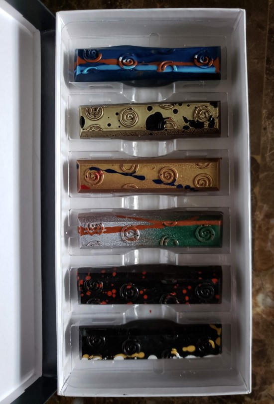 Six small chocolate bars in a single box. Refer to caption.