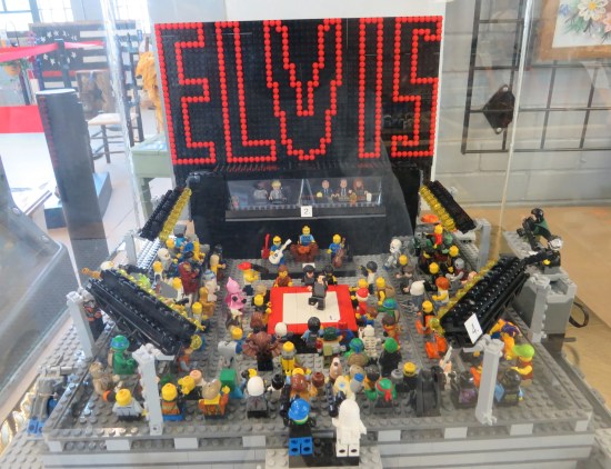 That iconic floor-to-ceiling ELVIS logo behind Lego Elvis playing a Lego theater in the round, which is square.