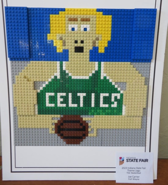 2-dimensional Lego portrait of Larry Bird, holding a basketball and wearing a green Boston Celtics jersey.