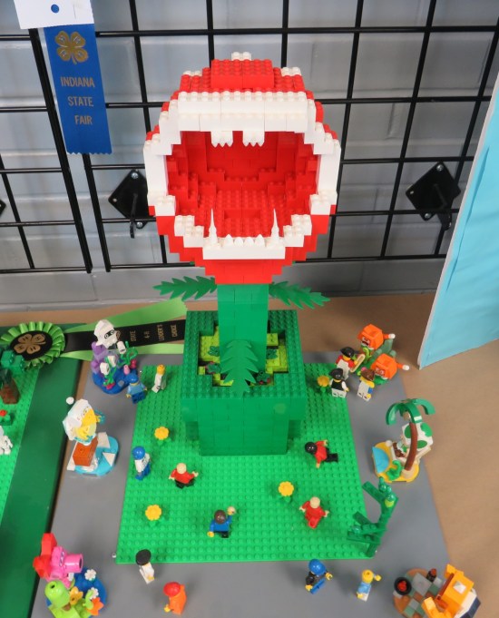 very tall Lego Piranha Plant surrounded by much shorter Lego characters.