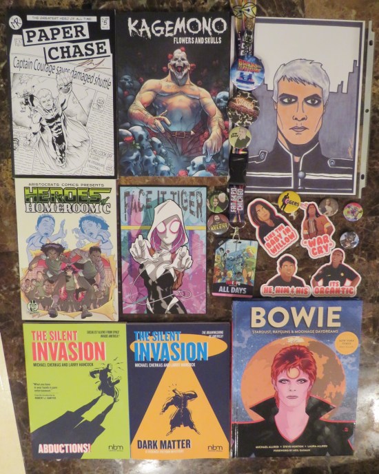 A bunch of books, drawings, buttons and pins.