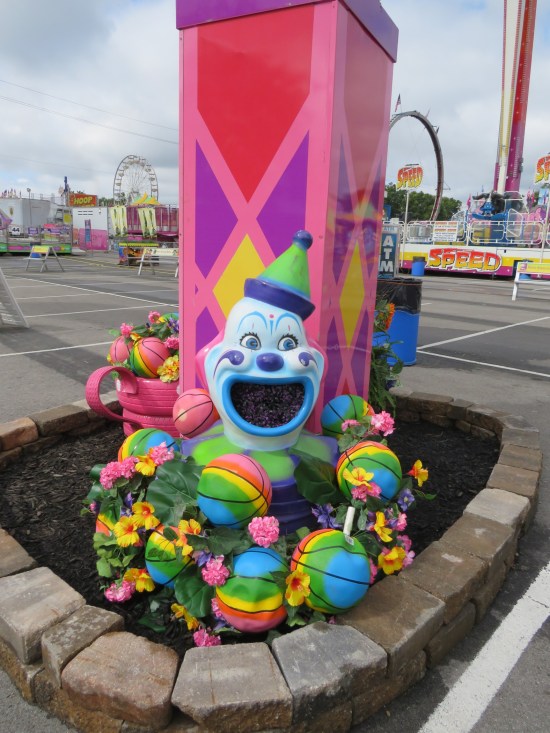 The leg of a different Midway arch, this one painted pink and surrounded with rainbow-painted basketballs and still another creepy clown head.