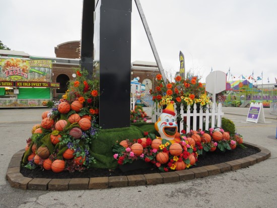 One side of the Midway's gateway arch surrounded by basketballs, greenery, and one creepy clown head.